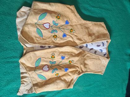 Beaded hide vest with floral sprays and a beaded yellow bird