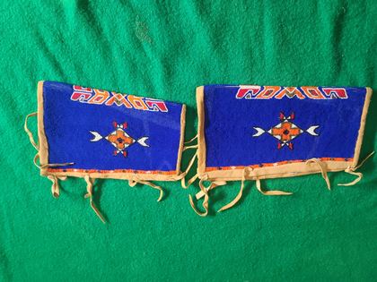 Matched pair of fully-beaded hide cuffs, cobalt field with crossed-arrow medallions, plate 76