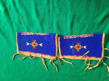 Matched pair of fully-beaded hide cuffs, cobalt field with crossed-arrow medallions, plate 79