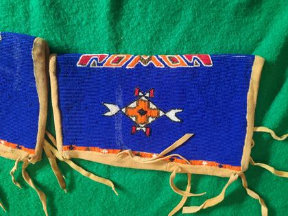 Matched pair of fully-beaded hide cuffs, cobalt field with crossed-arrow medallions, plate 80