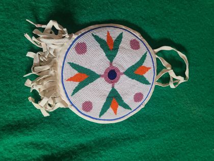 Round beaded rosette purse on white hide with fringe and tie handles, plate 85