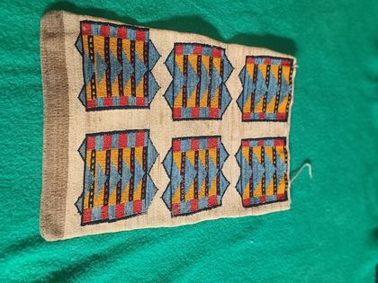 Plateau cornhusk flat bag — checkerboard diamonds one face, banded panels the other, plate 97