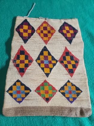 Plateau cornhusk flat bag — checkerboard diamonds one face, banded panels the other